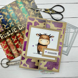Card sample using Rustic Cowhide papers — a little brown cow framed by rainbow and purple cowhide-print panels.