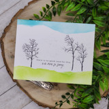 Soft watercolor horizon card with two bare trees and the no-good-card sympathy sentiment