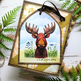 Tag with the moose in wildflowers under a blue sky, "I a-moose you" sentiment, black ribbon