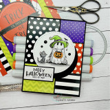 Card with ghosts and a jack-o'-lantern, black and orange striped papers, coloring markers nearby