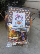 Treat bags with ghost-and-pumpkin toppers filled with candy