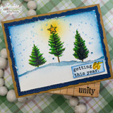 Blue winter scene card with three inked pine trees on a snowbank, a gold star and a “getting lit this year” tag on kraft.