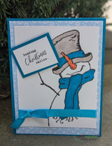 A top-hatted snowman in a scarf hand-stamped on a card and lettered "You put the merry in my Christmas."