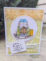 Card with the reading girl colored softly in a circle, and 'Between the pages of a book is a wonderful place to be' on a yellow patterned background.