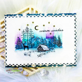 Northern-lights watercolor card with pines, deer, cabin, and 'warm wishes' under a starry sky.