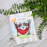 Encouragement card with a sleepy dog in a red hammock and the sentiment, “You deserve a pause.”