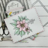 Pink scalloped card with a blush poinsettia beside “IT IS THE MERRIEST SEASON OF ALL,” styled with scissors and a paper pack.