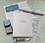 White card with the handmade-with-love back stamp beside Distress Ink pads and snowflake papers.