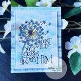 Card with the 'Cast all your cares upon Him' dandelion stamped over a blue stenciled cloud background with dotted borders.