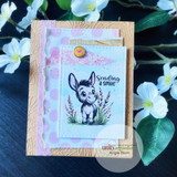 Card with the soft-colored donkey on pastel papers, "Sending a smile," white blossoms