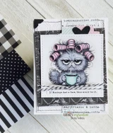 A cardmaking project featuring a grumpy cat in pink hair curlers clutching a coffee cup from Unity Stamp Co's Curlers & Catitude Pissy Kitty red rubber stamp set, with the sentiment 'If Mondays had a face, this would be it'.