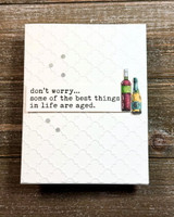 Minimalist white card with two small bottles and 'don't worry... some of the best things in life are aged.'