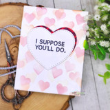 Pink heart-stenciled card with a stitched heart center reading 'I suppose you'll do.'