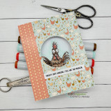 Card with a chicken-print cover and a small framed rooster image, scissors beside it