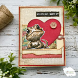 Red heart card of Bruce with a button and ledger paper on distressed white wood.