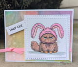 Soft pastel card with the grumpy bunny-eared cat colored brown, captioned 'Fluff off.'