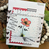 Wounds & Blooms card, the lone flower colored soft coral or purple over an inky distressed background, 'Every wound can bloom into wisdom'.