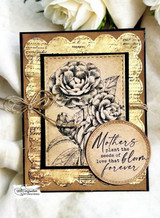 Vintage kraft and gold card with a script background, camellias stamped in sepia line art, twine bow, sentiment 'Mothers plant the seeds of love that bloom forever' on a round tag.