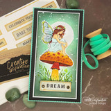 Slimline card with the winged fairy colored soft on an orange-stemmed mushroom in grass, framed in green, finished with a "Dream" tab.