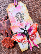 Bright pink-and-yellow mixed-media tag of a magenta moth with "The only lasting beauty is the beauty of the heart."