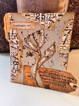 Mixed media card with torn number papers, a bronze tulip and the sentiment on a tag