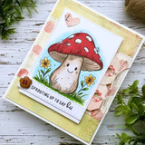 Kraft and pale yellow card with a soft blue sky panel, the toadstool coloured red with white spots, a wood button, sentiment 'SPROUTING UP TO SAY hi'.