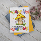 White card with a heart-print border, the toadstool coloured in yellow and orange with daisies, sentiment 'So mush love for you!', shown on grey and yellow envelopes.