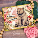 Sample card with the bear cub colored warm brown on a blush floral patterned panel with a green border and two stamped sentiment strips.