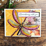 Bright card with the dragonfly in pink and gold over a floral panel, 'Remembering with you'