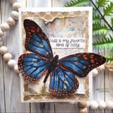 Card with a blue-and-orange colored monarch butterfly on a torn vintage-paper background and 'Fall is my favorite kind of cozy.'