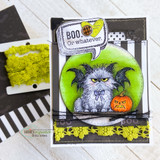Dark card with the bat-cat and pumpkin in a green circle over yellow lace trim, 'BOO. Or whatever.'