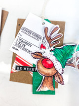 Kraft tag card with the reindeer in a green cap and 'BE MERRY.'