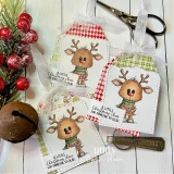 Handmade sample card made with the I'll Be Home for Christmas papers — two cute reindeer gift tags with small greetings, styled with red berries on a rustic surface.
