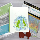 Clean white Christmas card with green pop-out pines over a holographic foil burst, shown with pear and blue ink pads and silver transfer sheets.