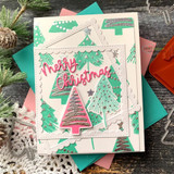 Teal and pink Christmas card with a stamped tree background behind a scalloped frame, a pink glitter pine, and a pink Merry Christmas die-cut.