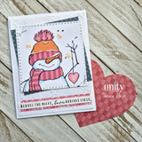 Snowman in an orange hat on a soft card holding a red die-cut heart.