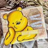 Softly watercolored golden bear rests his chin on his paw over a script-print kraft panel, with tucked sentiment strips reading "You are braver than you think. And loved more than you know." and "Hello beautiful."