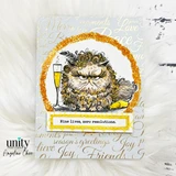 Gold foil new year card with a scowling curly cat and champagne flute inside a glittered gold circle, stamped with 'Nine lives, zero resolutions.' on a script-covered background.