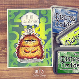 Green card of the ginger fluffy cat beside distress ink pads, 'fluff. it's all fluff.'
