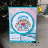 Handmade card made with Unity Stamp Co’s The Softest Thoughts red rubber stamp set — a fluffy bunny in a knit beanie hugging a heart, with a snowflake — stamped and colored, with the sentiment “Sending a big squeeze”.