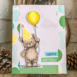 Card of the teddy in a party hat with a yellow balloon and a happy-birthday tag.
