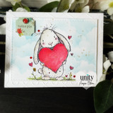A colored card featuring a wide-eyed, smiling cartoon bumblebee from Unity Stamp Co's Peek-A-Bee red rubber stamp set, with the sentiment 'You're un-BEE-lievably amazing!'.