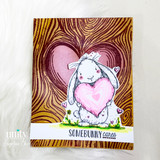 Card of the bunny with a pink heart over a woodgrain heart background, 'somebunny cares.'