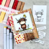 A handmade card featuring a shaggy Highland cow with a little bird perched on its head, in a wildflower meadow from Unity Stamp Co's Seen & Herd red rubber stamp set, with the sentiment 'Heard you were having a day, we are here for you'.