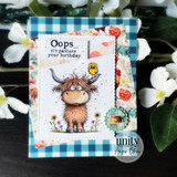 A handmade greeting card with a shaggy Highland cow with a little bird perched on its head, in a wildflower meadow from Unity Stamp Co's Seen & Herd red rubber stamp set, with the sentiment 'Just saying hey & hoping you're okay'.