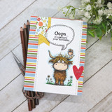 A handmade card featuring a shaggy Highland cow with a little bird perched on its head, in a wildflower meadow from Unity Stamp Co's Seen & Herd red rubber stamp set, with the sentiment 'Heard you were having a day, we are here for you'.
