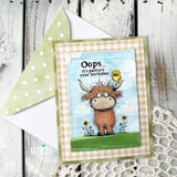 A colored card featuring a shaggy Highland cow with a little bird perched on its head, in a wildflower meadow from Unity Stamp Co's Seen & Herd red rubber stamp set, with the sentiment 'Sorry for being so moody!'.