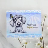 Handmade card with a sad-eyed puppy and a little butterfly under the sentiment 'Just when you need it most... hope appears', on a soft blue watercolor sunburst.