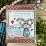 A stamped card showcasing a nerdy bunny in big round glasses and denim overalls, surrounded by books from Unity Stamp Co's Clever Cottontail red rubber stamp set, with the sentiment 'You have big brain energy'.