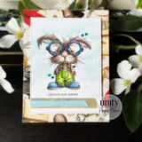A handmade card featuring a nerdy bunny in big round glasses and denim overalls, surrounded by books from Unity Stamp Co's Clever Cottontail red rubber stamp set, with the sentiment 'Here's to your success'.